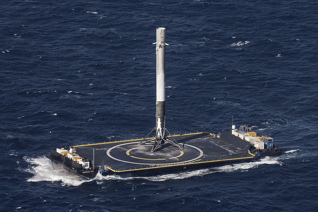Prvý stupeň nosnej rakety Falcon 9 spoločnosti SpaceX po úspešnom návrate na pristívaciu plošinu. Kredit: Wikipedia.