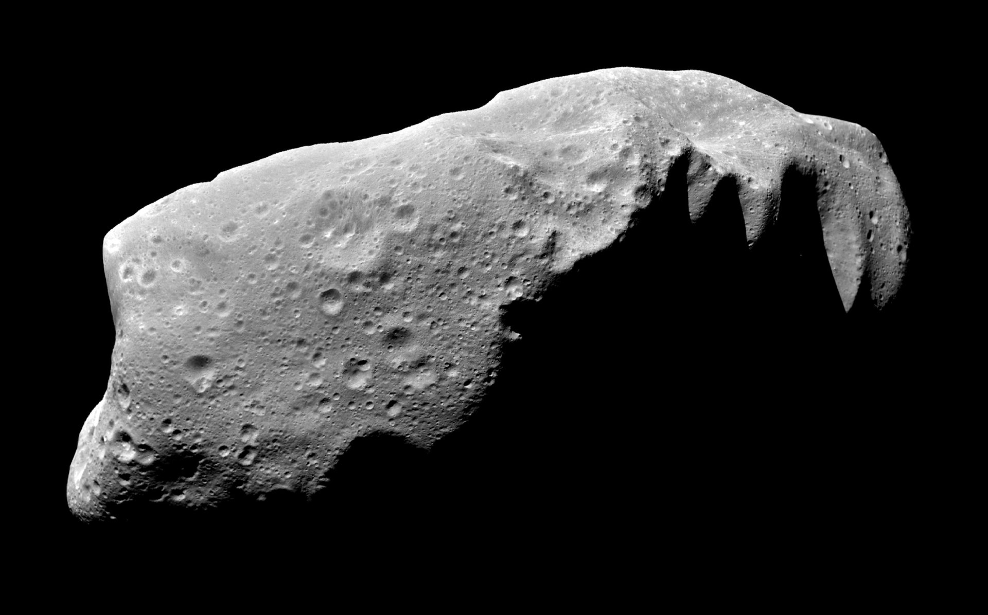 Vypadal právě takto asteroid, který se před 66 miliony lety osudově střetl se Zemí? Je to možné, ačkoliv přesný původ tohoto „temného a primitivního“ poutníka Sluneční soustavou stále neznáme. Na složeném snímku planetka 243 Ida, navštívená v roce 19