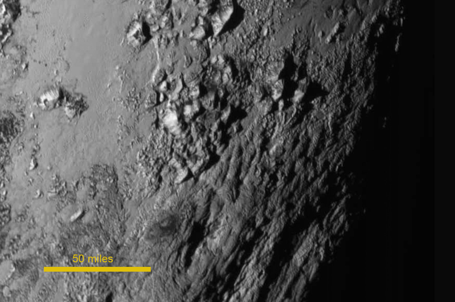 SnĂ­mek Pluta z kamery LORRI poĹ™Ă­zenĂ˝ zhruba 90 minut pĹ™ed maximĂˇlnĂ­m pĹ™iblĂ­ĹľenĂ­m. Hory jsou zĹ™ejmÄ› tvoĹ™eny ledem. Zdroj: http://www.nasa.gov/