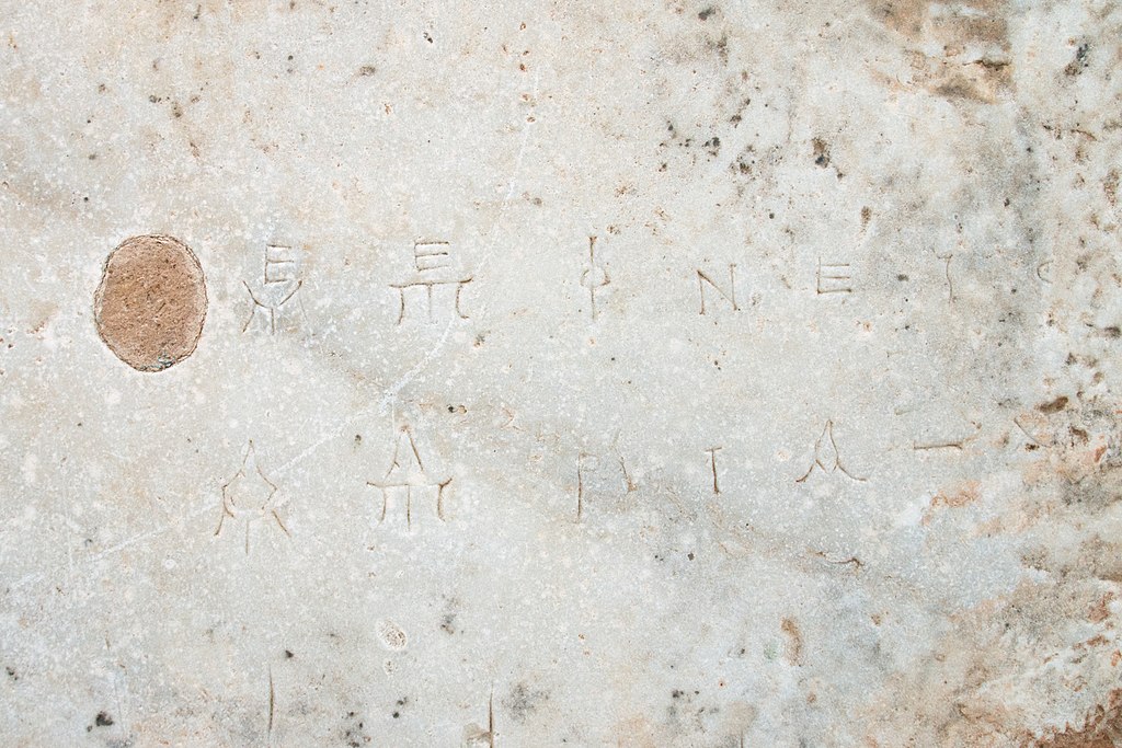 Mramorová deska s vyrytými hudebními nebo matematickými symboly, detail. Kredit: Wikimedia Commons.