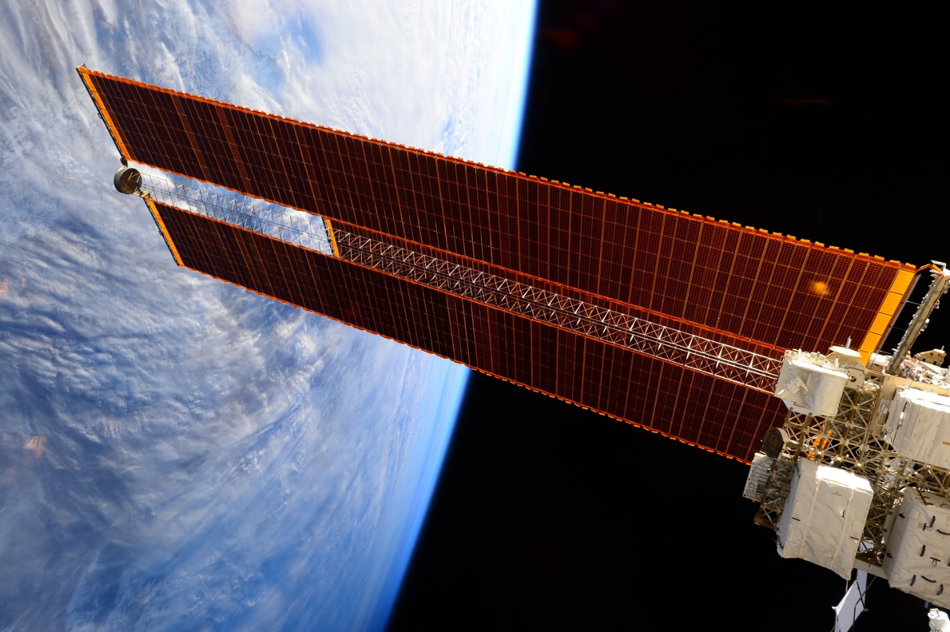 SolĂˇrnĂ­ panely vesmĂ­rnĂ© stanice ISS (zdroj kosmonautka Samantha CristforettiovĂˇ, NASA).