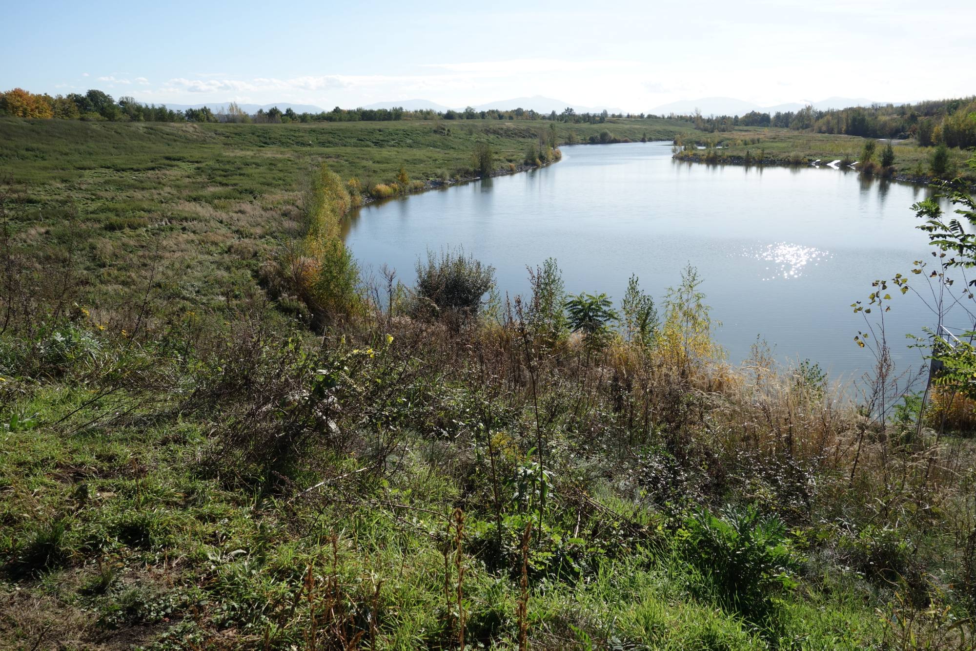 Umělé jezero na Haldě Hrabůvka. Pohled směrem na jih. V pozadí panorama Beskyd. Foto: A. Uhlíř, říjen 2023.