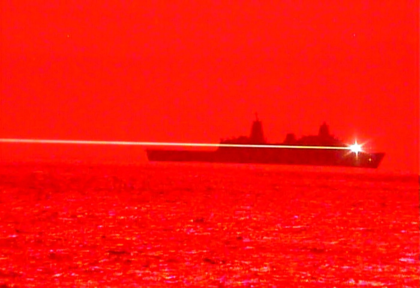 USS Portland pálí z laserového systému. Kredit: U. S. Navy.
