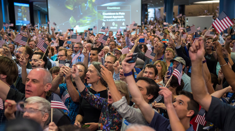 HostĂ© a ÄŤlenovĂ© tĂ˝mu New Horizons ÄŤekajĂ­ na nejbliĹľĹˇĂ­ prĹŻlet sondy New Horizons kolem Pluta. SnĂ­mek byl poĹ™Ă­zen na Johns Hopkins University Applied Physics Laboratory (APL) ve mÄ›stÄ› Laurel, stĂˇt Maryland. Zdroj: http://www.nasa.gov/