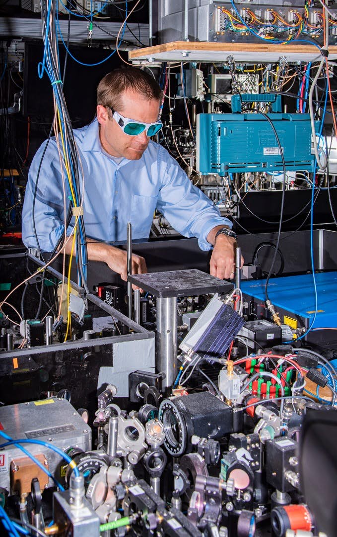 Andrew Ludlow s jedněmi z experimentálních atomových hodin. Kredit: Burrus/NIST.