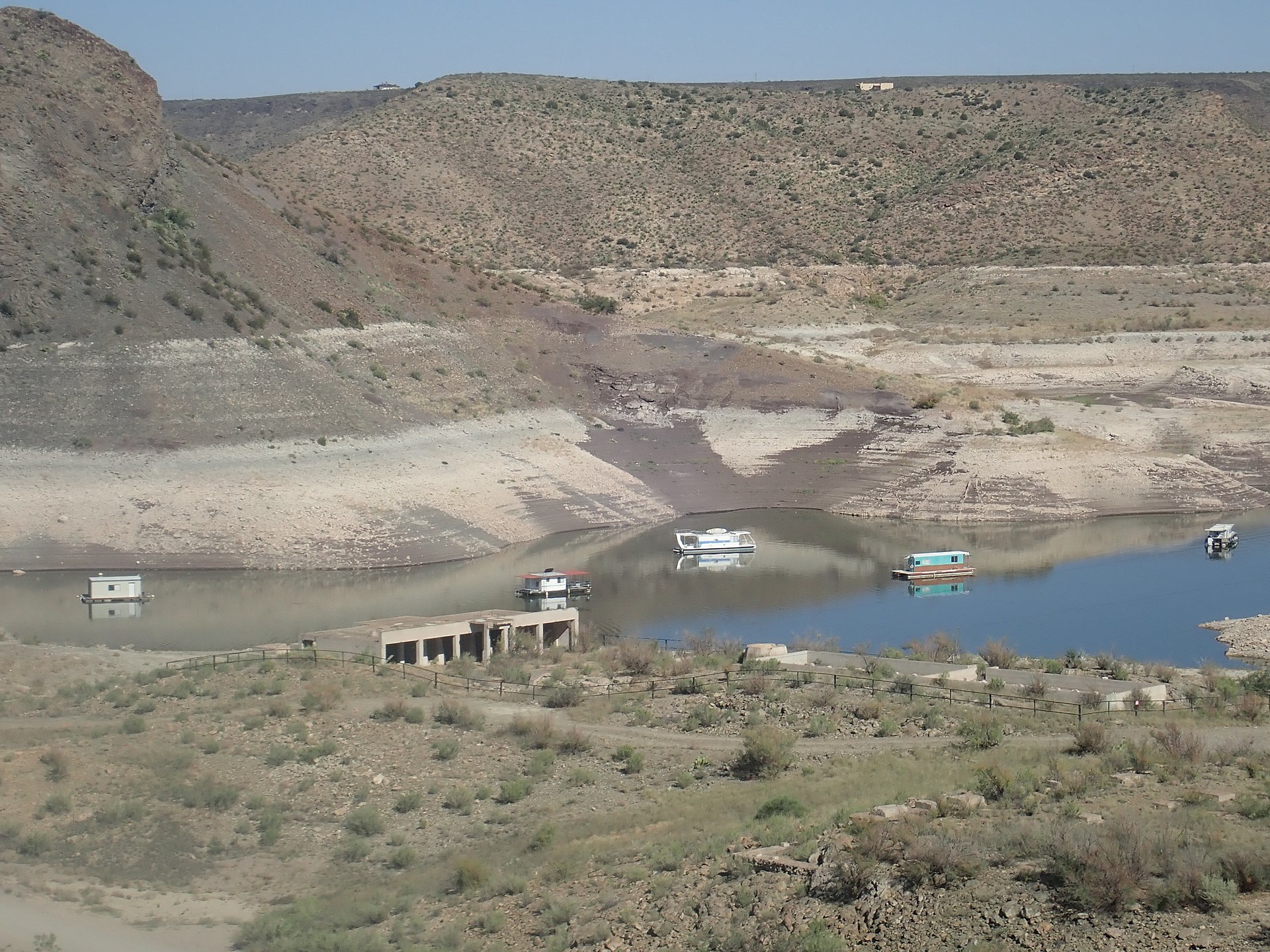 Pohled na odkryté sedimenty geologického souvrství McRae na území Nového Mexika. Při poklesu vodní hladiny v místní přehradní nádrži Elephant Butte byla před čtyřiceti lety objevena i částečně dochovaná spodní čelist obřího tyranosaurida. Kredit: Ken