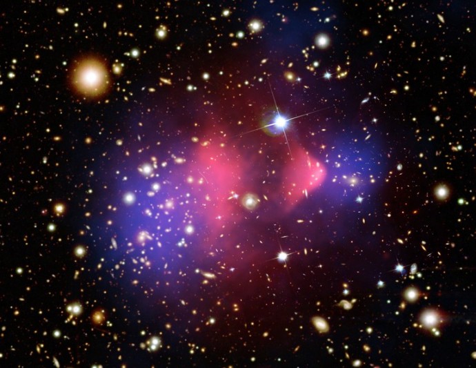 Kupa galaxií Kulka - 1E 0657-558 v optickém, rentgenovském oboru (červeně) a zobrazení výsledků gravitačního čočkování (modře). (Zdroj NASA)