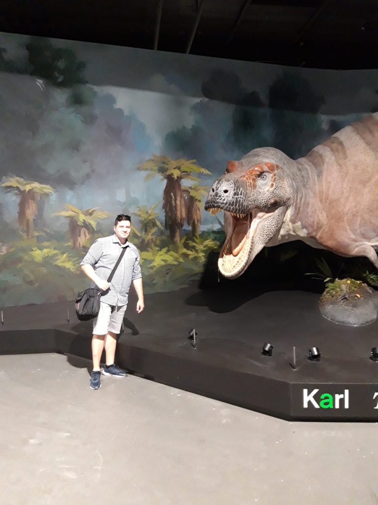 Autor u modelu tyranosaura zvaného „Karl“, krátce před oficiálním otevřením expozice Dinosauria Museum Prague (začátkem září letošního roku). Ačkoliv čelisti obřího teropoda mohly být i citlivé a „něžné“, nejspíš jen málokdo by si to chtěl vyzkoušet 