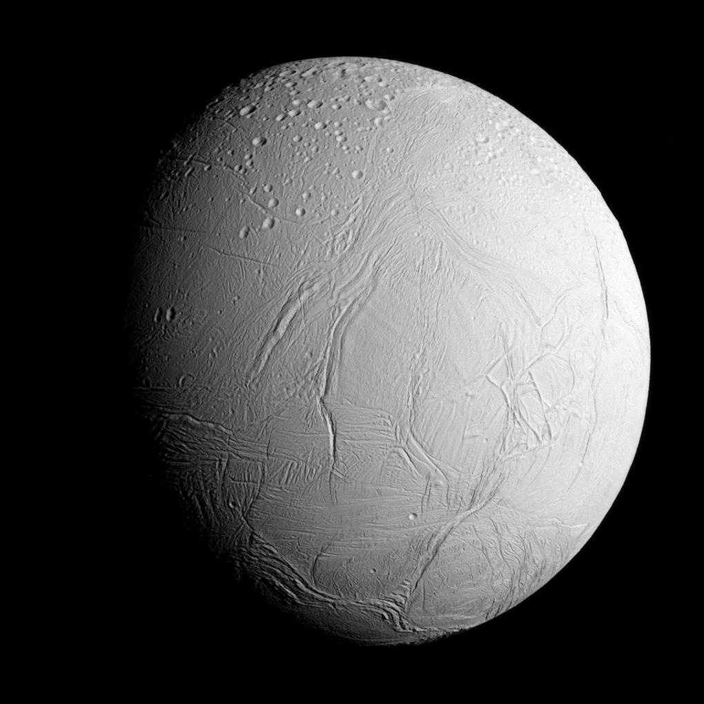 AÄŤkoli je Enceladus MimasovĂ˝m sousedem, skrĂ˝vĂˇ pod svĂ˝mi ledovci bohatĂ© zdroje vnitĹ™nĂ­ho tepla a kapalnĂ˝ oceĂˇn (NASA/JPL)