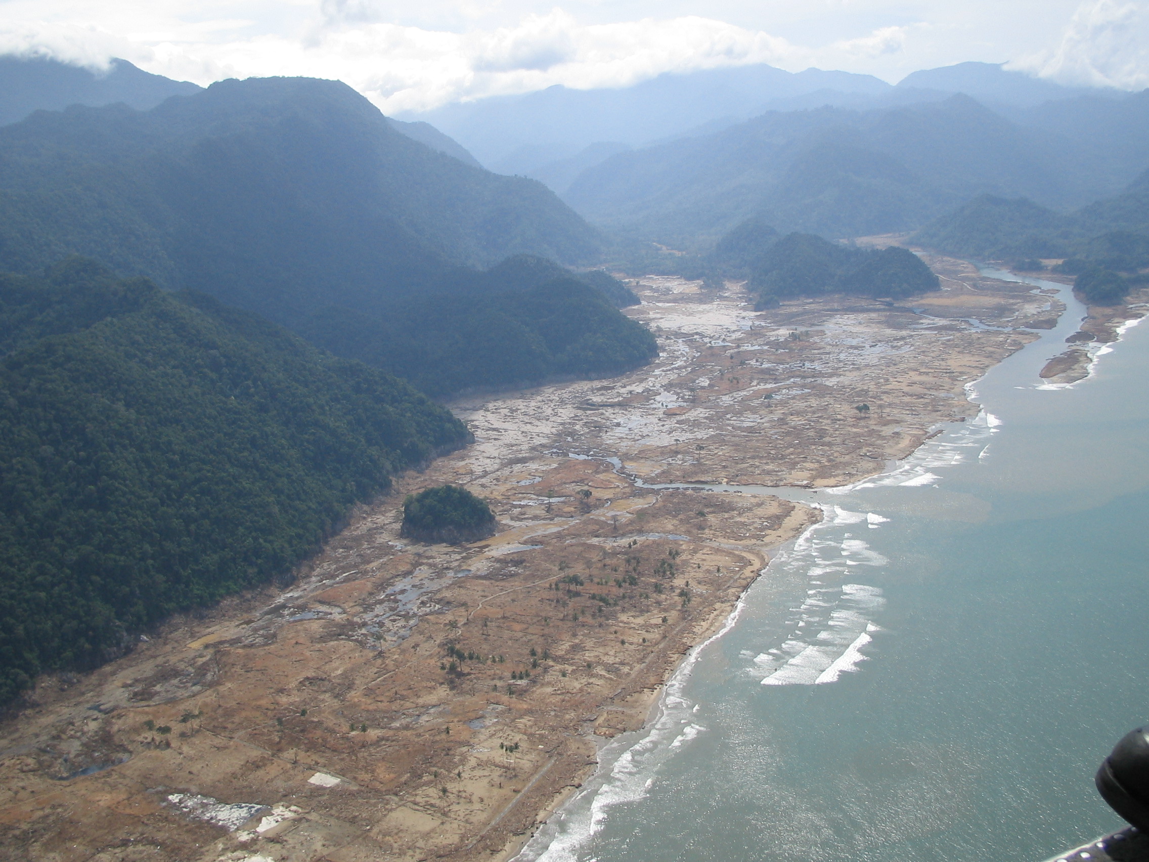 Indonéské pobřeží v oblasti Aceh na Sumatře, zasažené tsunami v prosinci 2004. Ani tato novodobá katastrofa se zdaleka neblížila projevům impaktní tsunami, která zdevastovala pobřeží Severní Ameriky až do hloubky desítek kilometrů. Kredit: AusAID, Wi