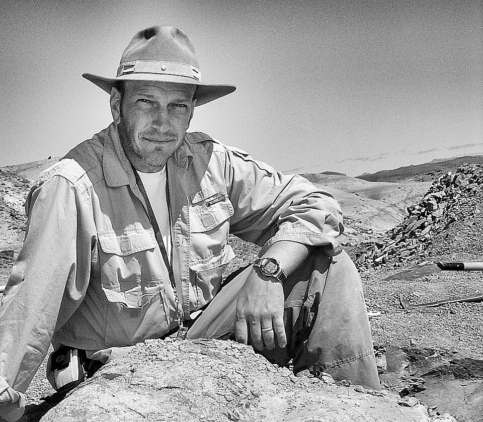 Americký paleontolog Kenneth J. Lacovara na patagonské lokalitě v souvrství Cerro Fortaleza (provincie Santa Cruz, jižní Argentina), kde byl Dreadnoughtus schrani objeven. Na snímku s částí stehenní kosti obřího sauropoda. Kredit: ArcaneHalveKnot; Wi