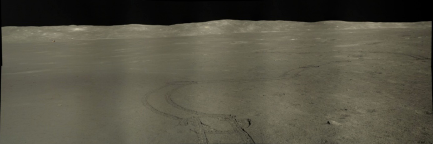 Panoramatický snímek pořízený Nefritovým králíkem 2 zobrazuje jeho vytlačené koleje a vzdálený přistávací modul Čchang-e 4 po několikaletém pobytu na měsíčním povrchu (zdroj NASA/GSFC/Arizona State University).