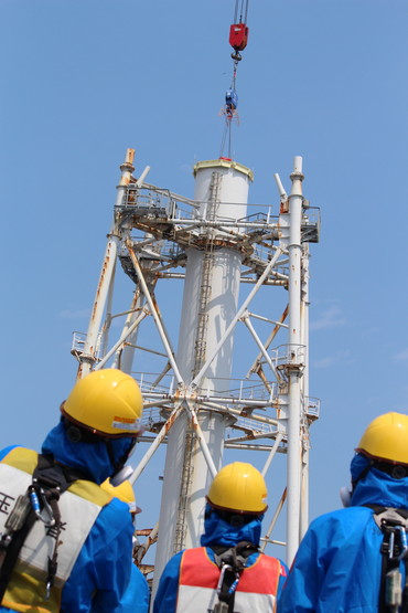 Instalace víka na společný ventilační komín prvního a druhého bloku po jeho zkrácení o polovinu (zdroj TEPCO).
