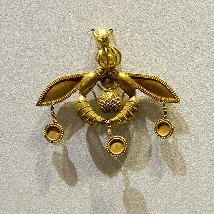 „Včelí ornament“, zlato, přívěšek velký 4 cm. Z pohřebiště Chrysolakos u Malie, 180-1700 před n. l. Archeologické muzeum v Irakliu (Herakleon), AE 559. Kredit: Zde, Wikimedia Commons.