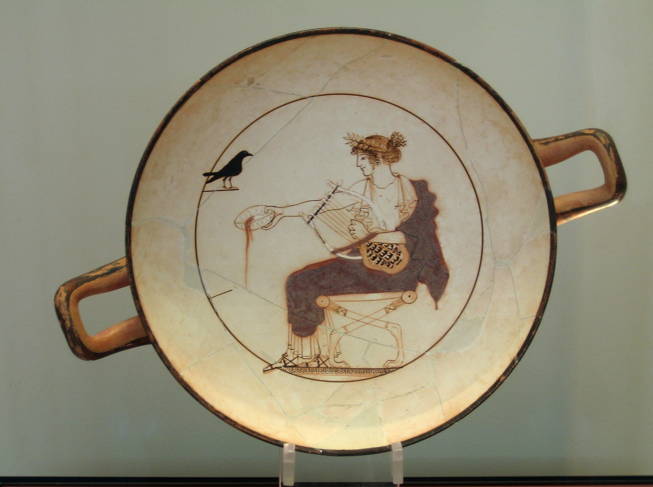 Apollón s lyrou krmí černého ptáka, pravděpodobně vránu. Wikimedia Commons