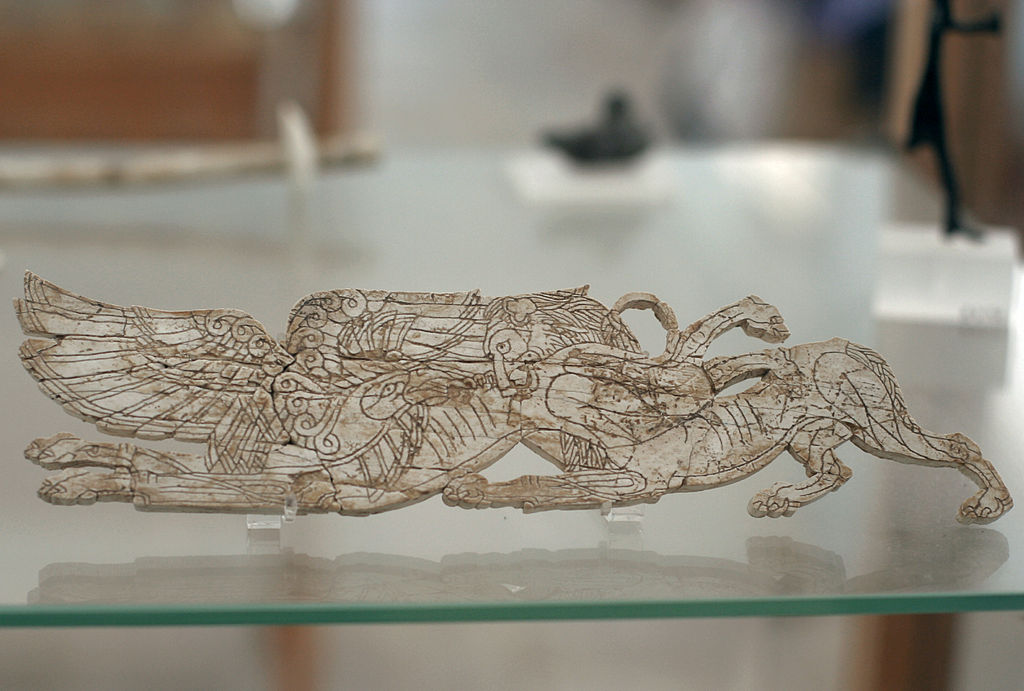 Okřídlený gryfón a lev s hady, slonovina, pozdní doba bronzová. Archeologické muzeum na Délu, B 7075. Kredit: Zde, Wikimedia Commons. Licence CC 3.0