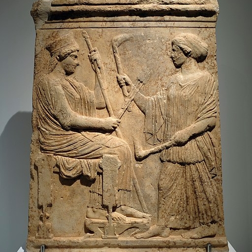 Démétér drží klasy a žezlo, Koré k ní přichází s pochodněmi, 500 až 475 před n. l. Archeologické muzeum v Eleusině 5085. Kredit: Davide Mauro, Wikimedia Commons.