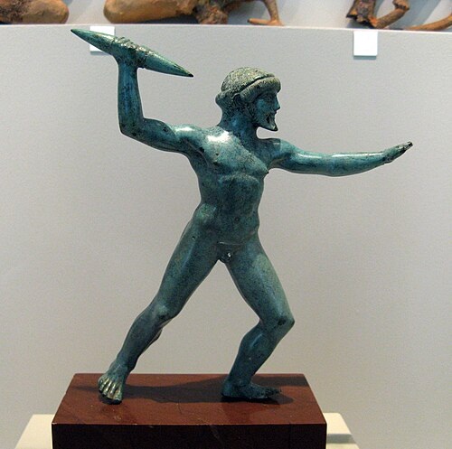 Zeus s bleskometem nebo hromoklínem, drobný bronz, 12,5 cm. Dódóna, 475-450 před n. l. Antikensammlung Berlin, Altes Museum, Misc. 10561. Kredit: Mark Landon, Wikimedia Commons. Licence CC 4.0.