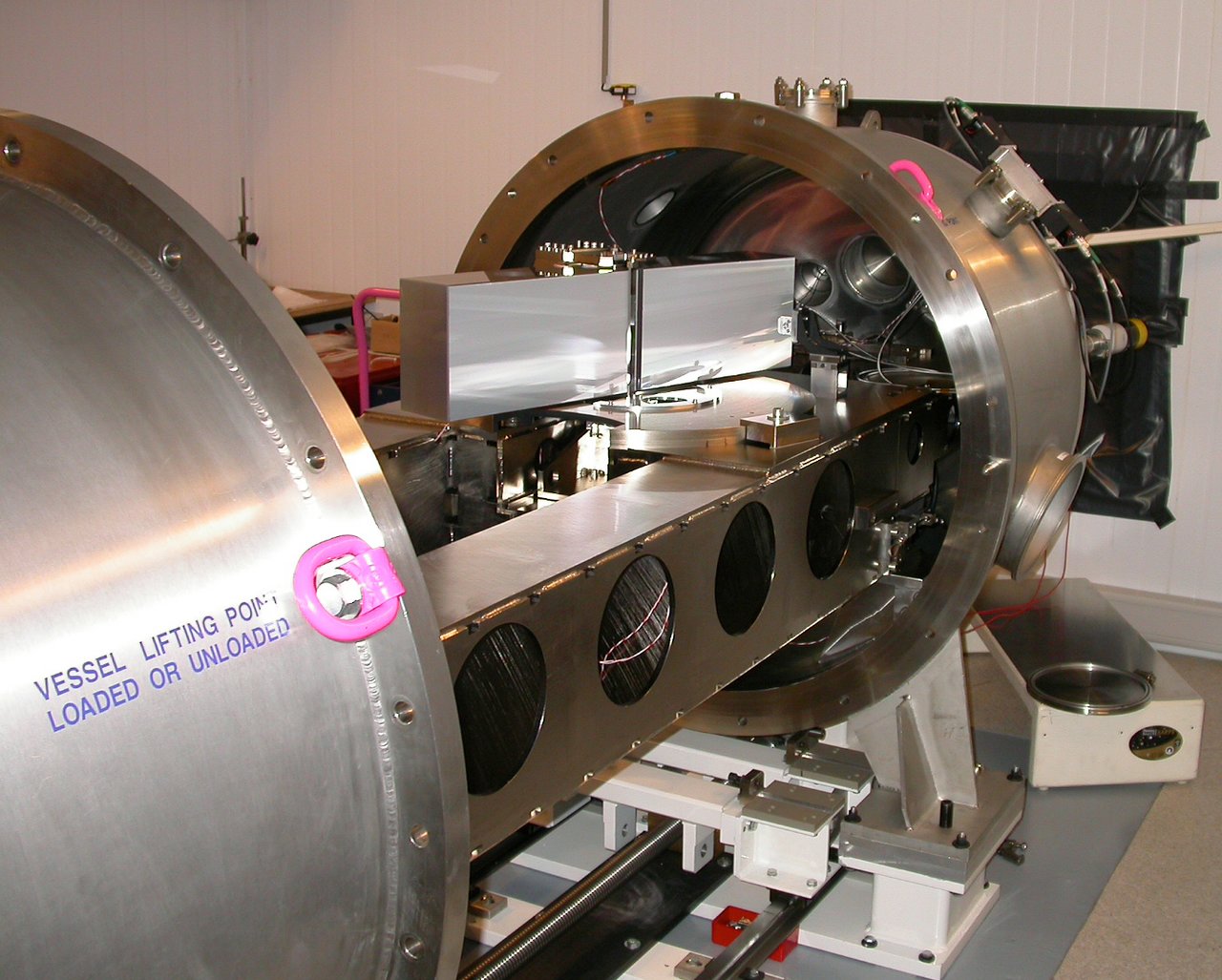 Spektrograf HARPS. Na snímku je otevřená vakuová nádrž, a tak lze vidět některé z vnitřních součástí. Například k lavici připevněná optická mřížka rozptylující přicházející světlo  o rozměrech  200 x 800 mm. Kredit: ESO.