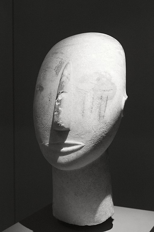 Hlava bohyně z Amorgu se zbytky polychromie, mramor je z ostrova Paru, 2800-2300 před n. l. Oči jsou zobrazeny malbou. Ve tváři jsou namalované čtyři svislé pruhy, původně prý byly červené. Národní archeologické muzeum v Athénách, č. 3909. Kredit: Zd