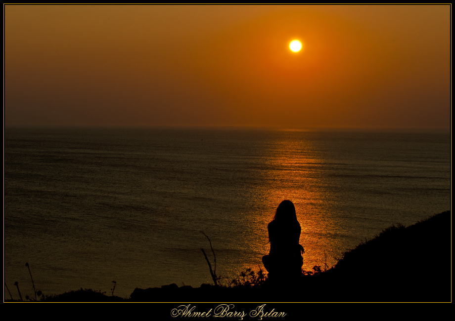 „Mys Polent na ostrově Bozcaada, proslulý západy slunce.“ Kleostrátos zde ovšem pozoroval z větší výšky a v jinou hodinu než tato turecká dívka. Kredit: Ahmet Baris Isitan, Wikimedia Commons. Licence CC 3.0.