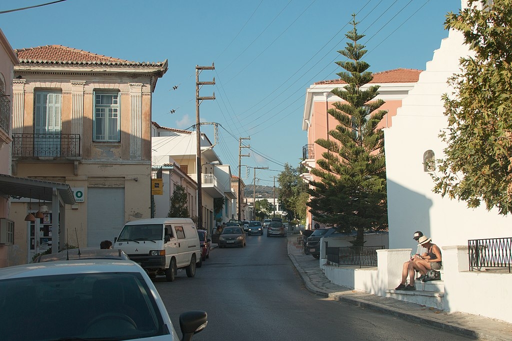 Od zastávky v Chalki. Tahle hlavní silnice pokračuje do Filoti, destilérka je v uličce hned vlevo. Kredit: Zde, Wikimedia Commons. Licence CC 4.0.