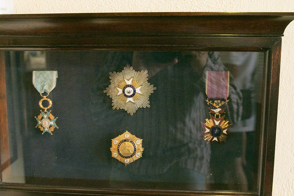Medaile, které produkt likérky v Chalki obdržel začátkem 20. století. Uprostřed jsou medaile z roku 1904, nahoře z Bordeuax, dole z Marseille. Kredit: Zde, Wikimedia Commons. Licence CC 4.0.