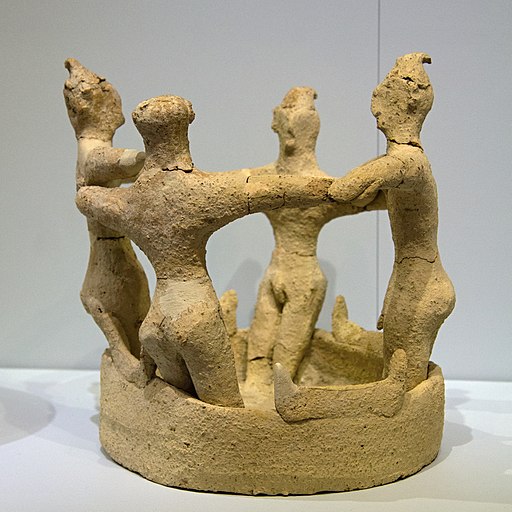 Čtyři muži v kruhovém tanci, v prostoru, který je ohraničen rohy zasvěcení, což značí náboženský charakter scény. Kamilari, období nových (druhých) paláců, 1650-1450 před n. l. Archeologické muzeum v Irakliu (Herakleion), skříň 98. Kredit: Zde, Wikim