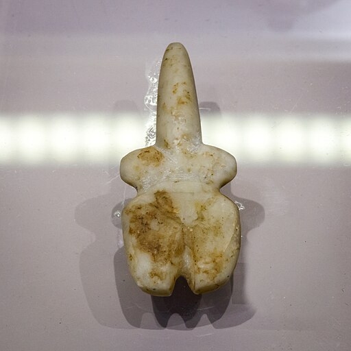 Schematická figurka ženy (bohyně?) stylizovaná do tvaru violy. Import z Kyklad začátkem rané doby bronzové (EC I), 3200-2800 před n. l. Archeologické muzeum v Rethymnu. Kredit: ArchaiOptix, Wikimedia Commons. Licence CC 4.0.