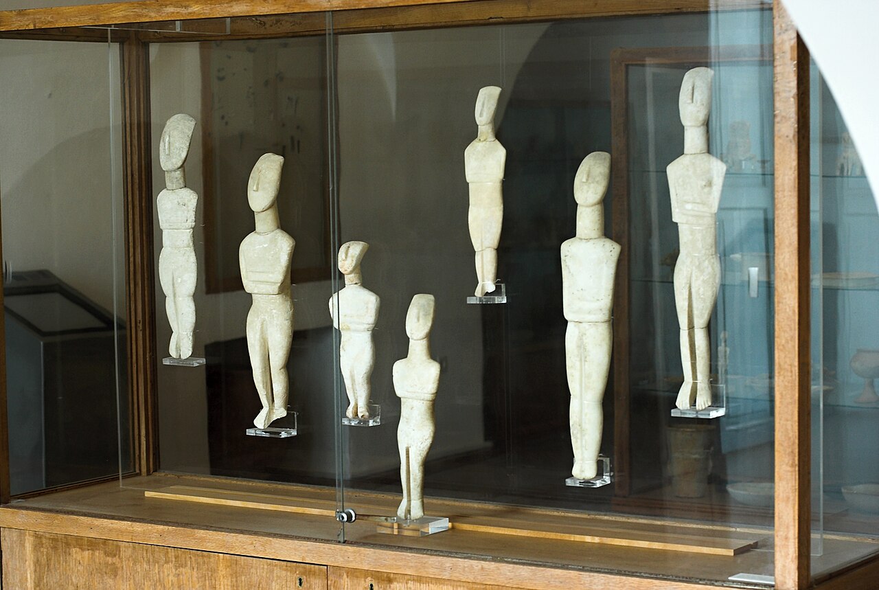 Archeologické muzeum na Naxu, kykladská sbírka, skříň 3: Kykladské idoly kanonického typu (EC II) z různých míst naxijského venkova. Kredit: Zde, Wikimedia Commons. Licence CC 3.0.
