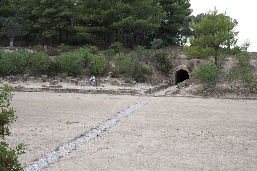 Sedadla pro diváky v prostoru mezi startem a tunelem pro příchod i odchod ze stadionu. Nemea, 320 před n. l. Kredit: Zde, Wikimedia Commons. Licence CC 4.0.