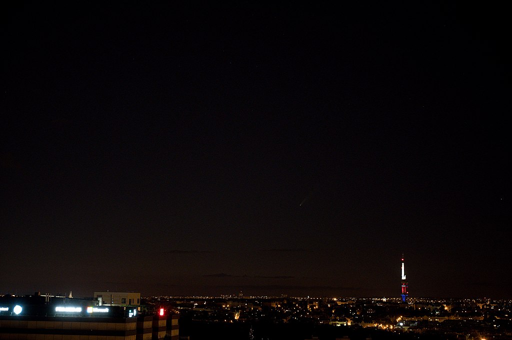 Kometa C/2020 F3 (NEOWISE),11. 7. 2020 v 23?19 letního středoevropského času. Z Prahy 4, z balkónu paneláku (vpravo je žižkovská věž). Kredit: Zde, Wikimedia Commons.