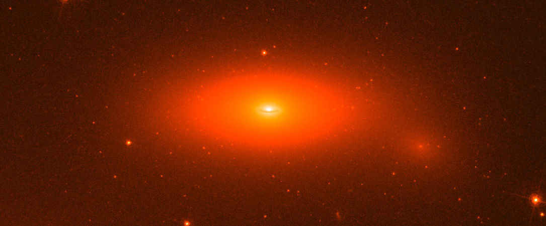 Galaxie NGC 1277 na snímku Hubbleova dalekohledu. Kredit: NASA / ESA / Andrew C. Fabian / Remco C. E. van den Bosch (MPIA).