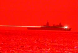 USS Portland pálí z laserového systému. Kredit: U. S. Navy.