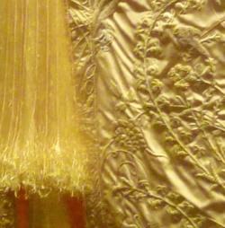 Detail zlatého roucha Plášť z madagaskarského pavoučího hedvábí Golden Orb vystavený v londýnském Victoria and Albert Museum v červnu 2012. Kredit: Cmglee, Wikimedia Commons, CC BY-SA 3.0 (výřez)