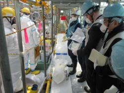Delegace pracovníků Mezinárodní agentury pro atomovou energii kontroluje odběr vzorků vody, která byla vyčištěna zařízením ALPS. Odvezou je sebou pro nezávislou kontrolu (zdroj TEPCO).