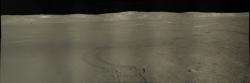 Panoramatický snímek pořízený Nefritovým králíkem 2 zobrazuje jeho vytlačené koleje a vzdálený přistávací modul Čchang-e 4 po několikaletém pobytu na měsíčním povrchu (zdroj NASA/GSFC/Arizona State University).