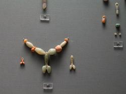 Falický náhrdelník a dva malé přívěsky, polodrahokamy a barevné kameny, 3200-2800 před n. l. Pohřební dary z Krassades na Antiparu, z hrobu 115. Národní archeologické museum v Athénách, inv. č. 4861. Kredit: Zde, Wikimedia Commons.