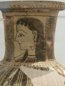 Dívka na hrdle keramické nádoby z ostrova Paru (Parosu). Náušnice je zakotvena také ve tváři, 700-500 před n. l. Archeologické muzeum na Mykonu. Kredit: Zde, Wikimedia Commons.