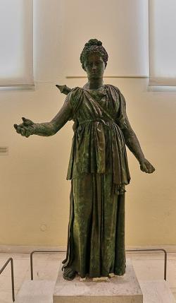 Bronzová socha Artemidy v přibližně životní velikosti. Praxitelova škola, pozdní 4. století před n. l. V pravé ruce drží misku na úlitbu a v levé ruce luk. Na zádech nese toulec na šípy. Archeologické muzeum v Pireu 4648. Kredit: George E. Koronaios, Wikimedia Commons. Licence CC 4.0.