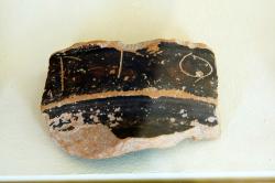 Fragment keramické nádoby s vyrytým nápisem, pravděpodobně jmen Apollóna a Artemidy. Archeologické muzeum na Paru. Kredit: Zde, Wikimedia Commons. Licence CC 4.0.