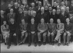 Dublinský institut pro pokročilá studia v roce 1942: dolní řada zleva: Sheila Tinney, Pádraig de Brún, Paul Dirac, Éamon de Valera, Arthur Conway, Arthur Eddington, Erwin Schrödinger, Albert Joseph McConnell. Druhý zleva v horním řadě je čínský teoretický a jaderný fyzik Peng Huanwu, který vedl vývoj čínské atomové a vodíkové bomby. 
Kredit: Cecil Keaveney, former Registrar of Dublin Institute for Advanced Studies.