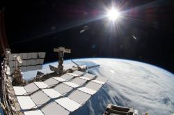 Pohled z Mezinárodní vesmírné stanice ISS na Zemi a Slunce. Snímek byl pořízen pomocí objektivu typu rybí oko připojeného k elektronické kameře. Kredit: NASA
