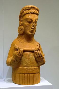 Bohyně s náušnicemi a náhrdelníkem, terakota. Praisos, 6. století před n. l. Archeologické muzeum v Irakliu (Herakleon). Kredit: Zde, Wikimedia Commons. Licence CC 4.0. Bohyně s náušnicemi a náhrdelníkem, terakota. Praisos, 6. století před n. l. Archeologické muzeum v Irakliu (Herakleon). Kredit: Zde, Wikimedia Commons. Licence CC 4.0.