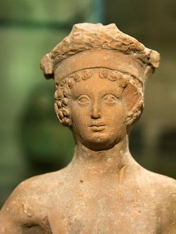 Mladý Dionýsos při hostině. Hlavu zdobí věnec s rozetami, kolem roku 400 před n. l. NM-H10 4777. Kredit: Zde, Wikimedia Commons. Licence CC 4.0.