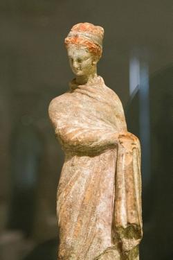 Žena v chitónu a himatiu, tzv. tanagra. Boiótie, pozdní 4. až 3. století před n. l. NM-H10 1873. Kredit: Zde, Wikimedia Commons. Licence CC 4.0.