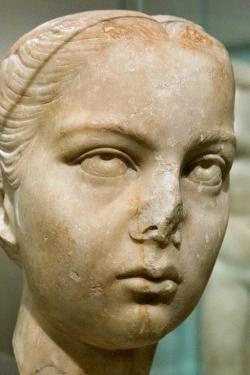 Portrét mladé Římanky, vlasy rozdělené nad čelem, vzadu svázané do uzlu. Mramor, 2. století n. l. NM-H10 739. Kredit: Zde, Wikimedia Commons. Licence CC 4.0.