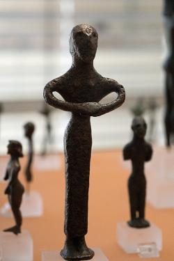 Postava ženy s rukama sepjatýma při modlitbě nebo obřadu. Drobný bronz v geometrickém stylu, snad kolem roku 700 před n. l. Archeologické muzeum v Delfách. Kredit: Zde, Wikimedia Commons. Licence CC 4.0.
