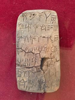 Tabulka s nápisem v lineárním písmu A, z paláce v Zakru. Archeologické muzeum v Sitii, H.M. 1627. Může zaznamenávat množství vína sumarizované na druhé straně tabulky. Kredit: Zde, Wikimedia Commons. Licence CC 4.0.