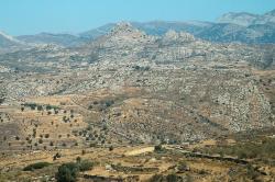 Východní část oblasti Cheimarros na Naxu od jihu, z okolí hlavní silnice do Chalki. Dominantou je hrad Apano Kastro nad obcí Tsikalario. Naxos. Kredit: Zde, Wikimedia Commons. Licence CC 4.0.